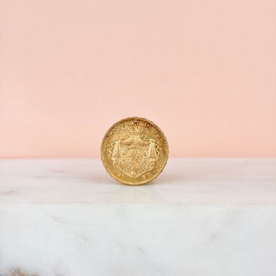 an image of a gold coin sitting on top of a marble slab
