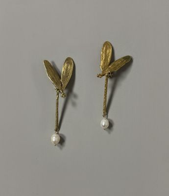 une paire de boucles d'oreilles ornées de feuilles et de perles
