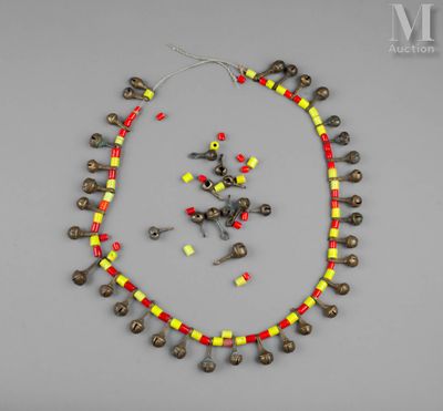 un collier orné de clochettes et de perles sur un fond gris