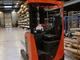 un chariot élévateur dans un entrepôt comportant de nombreuses étagères