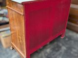 a red chest with a marble top sitting on the floor