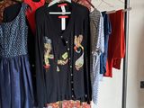 three dresses hanging on a clothes rack in a room