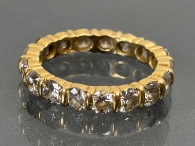 an image of a gold and diamond ring on a black surface