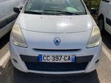 La voiture blanche est garée sur le parking, à côté de la camionnette blanche.