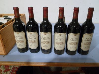 six bouteilles de vin rouge sont alignées sur une table