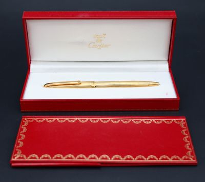 un stylo plaqué or dans un coffret rouge sur fond noir