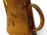 a brown pitcher with a handle on a white surface