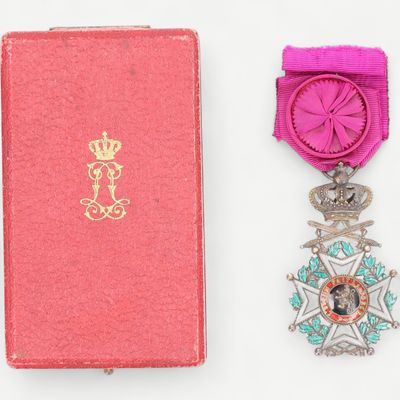 une image représentant une boîte rose avec une médaille et un ruban rose