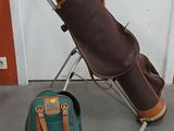 a bag of golf clubs and a pair of shoes on the floor