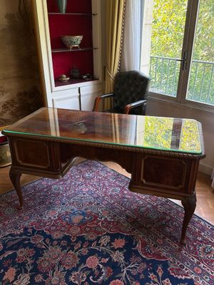 un bureau avec un plateau en verre, dans un coin de la pièce