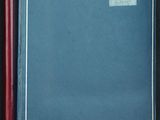 un livre bleu ouvert, à la couverture rouge, posé sur une table