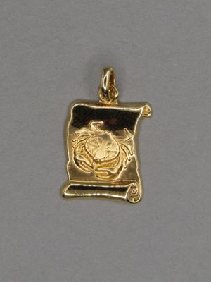 un pendentif plaqué or orné d'un crabe