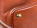 a brown leather bag sitting on a wooden table