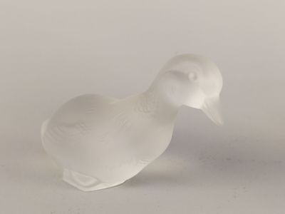 a white glass bird that is sitting on a table