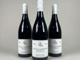 trois bouteilles de vin posées sur une table l'une à côté de l'autre