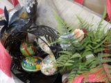 a basket full of eggs and plants on the ground
