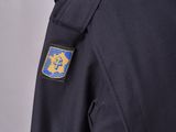the back of a police officer ' s uniform with a badge on it