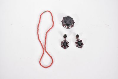 un collier, des boucles d'oreilles et un fil rouge sur un fond blanc