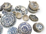 a pile of blue and white plates and bowls on a white surface
