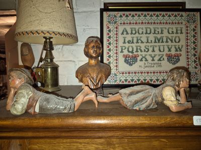 a statue of a boy and a girl laying on a table