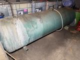 a large green pipe sitting in a room next to other containers