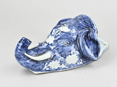 a blue and white elephant figurine sitting on a white surface
