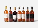 six bottles of wine are lined up in a row on a white surface