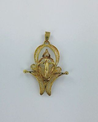 une image représentant un pendentif en or sur lequel figure un oiseau