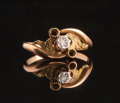 two gold rings with diamonds on a black surface