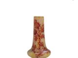 un petit vase avec un motif sur une surface blanche