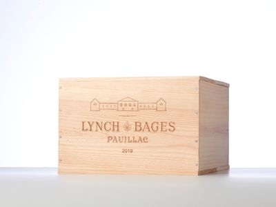 the wooden box is holding a bottle of wine on a white surface