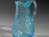 a blue glass pitcher that is sitting on a table