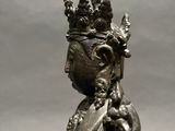 bronze statue of a seated person with a crown on his head