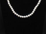 un collier de perles blanches sur un mannequin noir