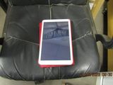 a tablet sitting on a black leather chair in a room