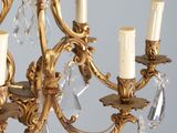 a gold chandelier with five candles and a crystal chandelier