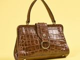 sac à main en cuir de crocodile marron sur fond jaune