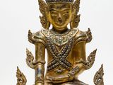 une image représentant une statue de Bouddha dorée posée sur une surface blanche