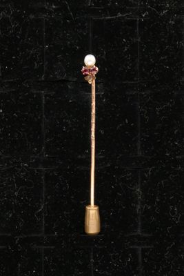 a close up of a gold stick with a pearl on it