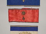 trois rubans de couleurs différentes accrochés les uns à côté des autres sur un mur