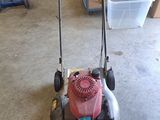 une image d'une tondeuse à gazon garée dans un garage
