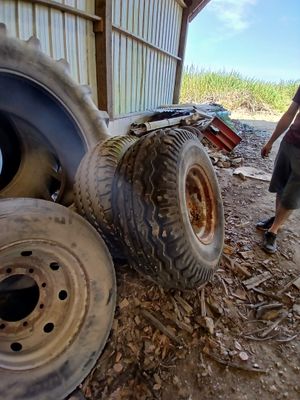 un homme qui se tient à côté d'un gros pneu