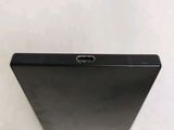 the back of a black tablet computer sitting on top of a white surface