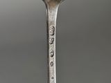 a spoon with a face on it sitting on a table