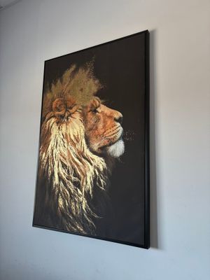 un tableau représentant un lion accroché au mur au-dessus d'un lit