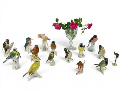 many figurines of birds and flowers in a vase