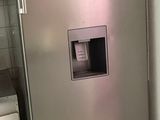 a stainless steel refrigerator in the corner of a kitchen