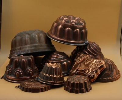 de nombreux gâteaux au chocolat en forme de bundt posés sur une table, surmontés d'un chapeau