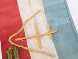 a small piece of fabric with a cross on it