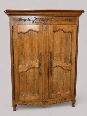 une vieille armoire en bois avec deux portes d'un côté et un tiroir de l'autre